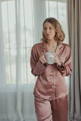 Pijama de satén elastizado color celeste, compuesto por una camisa de manga larga con cuello solapa, botones frontales y bolsillo en el pecho, y un pantalón recto con cintura elástica y lazo ajustable.