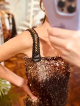 Vestido corto de fiesta con lentejuelas color cobre y negro degradado. Breteles anchos de cuero sintético negro con bordado dorado.