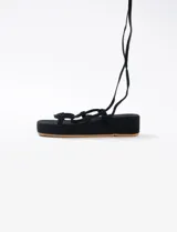 Sandalias con plataforma color naranja, tiras finas y ajuste con cordones al tobillo.