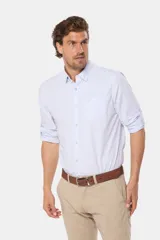 Camisa celeste a rayas verticales, de manga larga con opción de enrollar, corte slim fit, con bolsillo en el pecho y confeccionada en algodón.