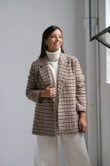 Blazer de corte recto con estampado a cuadros en tonos beige y marrón, con solapas clásicas y cierre frontal.