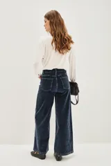 Pantalón de jean estilo corderoy negro, de corte wide leg y tiro alto, con bolsillos delanteros parcheados.