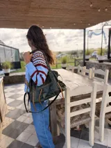 Sweater de lana con diseño de rayas horizontales en tonos celeste, bordó y beige.