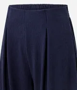 Pantalón largo femenino texturizado color azul marino, modelo aladim, con volumen amplio en las piernas y estrechamiento en el ruedo. Posee cintura elástica incorporada y pliegues delanteros.