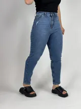 Pantalón de jean azul de tiro alto, corte mom y largo hasta el tobillo.