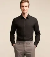 Camisa de corte regular confeccionada en microfibra, con cuello inglés, manga larga y cierre frontal abotonado. Presenta un diseño liso y minimalista, ideal para un estilo formal o de oficina.