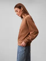 Buzo Calvin Klein de felpa francesa color marrón, con cuello redondo, mangas largas, puños y dobladillo acanalados, y el logo retro de la marca bordado en el pecho.