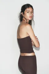 Top corto tipo bandeau color marrón oscuro, con escote recto y corte ajustado al cuerpo.