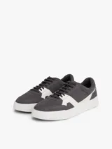 Zapatillas de tenis Tommy Hilfiger de corte bajo, confeccionadas en ante color gris con paneles en contraste de color blanco. Presentan cierre con cordones, suela de goma blanca y logo de la marca grabado en el lateral y el talón.