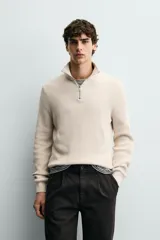 Jersey de punto perlado con cuello perkins y cierre frontal de cremallera. Presenta un corte regular fit, manga larga y acabados en rib en puños y bajo.