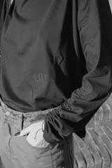 Remera negra de mangas largas con detalle de frunce en una manga y drapeado en el hombro.