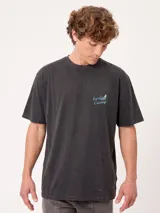 Remera oversize color beige de manga corta, con gran estampa colorida en la espalda con diseño de mapa de playa y la inscripción "Rusty County".