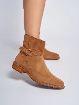Bota corta color beige de gamuza, con taco bajo y hebilla lateral.