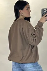 Buzo de cuello redondo, corte oversize, con mangas largas y puños elásticos.