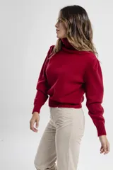 Polera de tejido de punto color negro, con cuello tortuga alto y puños y ruedo acanalados.