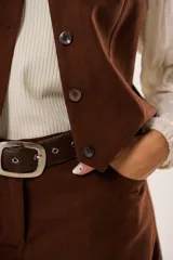 Chaleco marrón con escote en V, sin mangas y cierre frontal con botones.