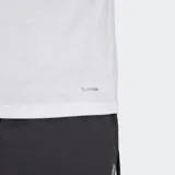 Remera deportiva Adidas de manga corta y cuello redondo, color blanco, con un logo grande estampado en el pecho que combina el logo performance con un patrón de camuflaje en tonos verde lima y amarillo.