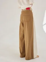 Pantalon ancho de denim en varios tonos de azul con diseño patchwork, de tiro medio y cierre frontal con botones.
