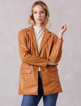 Blazer de eco cuero marca Baccini, con cuello de solapa, cierre frontal con botones y bolsillos delanteros aplicados. Presenta un corte oversize y forro interno a tono.