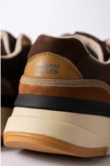 Championes urbanos Urban Haus modelo Julen, con diseño de paneles en tonos verde oliva y beige. Presentan una combinación de texturas en gamuza y material sintético, con suela de goma dentada en color caramelo.