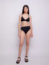 Top de bikini negro con estampado animal print, corte triangular, breteles finos regulables, gancho en espalda y copas desmontables.