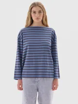 Remera de manga larga con calce holgado, confeccionada en algodón. Presenta un diseño a rayas horizontales en tonos beige y negro, con bordado de letras SP en el pecho y estampa de la marca en la manga.