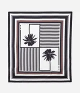 Pañuelo cuadrado de tela satinada con diseño geométrico de rayas y estampado de palmeras en tonos blanco, negro y marrón.