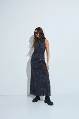 Vestido corto sin mangas, con cuello alto y ajuste al cuerpo, confeccionado en tejido de malla con estampado animal print en tonos grises y negros.