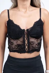 Top negro de encaje con breteles finos y escote corazón con cordones cruzados.