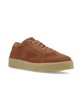 Championes de gamuza color marrón con cordones al tono y suela de goma texturizada en color beige.