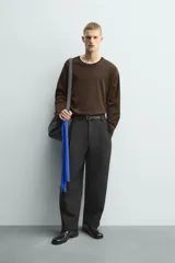 Camiseta de manga larga y corte relajado en color marrón oscuro. Presenta un diseño de doble capa en el cuello y el ruedo, con un borde interior en color blanco que crea un efecto de contraste.