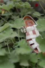 Sandalias tipo huarache de cuero con diseño de tiras entrelazadas, punta cerrada y cierre con hebilla lateral. Cuentan con suela plana y plantilla con logo grabado.