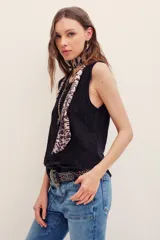 Musculosa negra de encaje con cuello redondo y diseño sin mangas, de corte holgado.