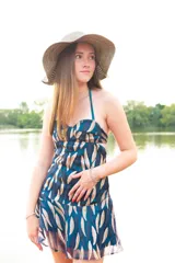 Vestido corto con top tipo corset y breteles finos, falda con volados y estampado de hojas en tonos azul y dorado.