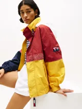 Campera de nailon con diseño color block en rojo, amarillo y azul marino. Tiene cuello alto, cierre de cremallera oculto con botones a presión, puños y bajo elásticos, dos bolsillos ribeteados en la cintura y logo de Tommy Hilfiger en la parte delantera, la trasera y las mangas.