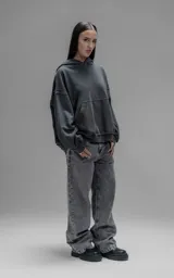 Hoodie oversize de algodón con efecto desgastado, costuras expuestas y roturas decorativas. Presenta capucha, bolsillo frontal tipo canguro y terminaciones deshilachadas.