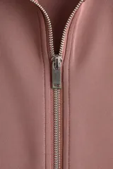 Campera deportiva corta de punto grueso con leve brillo, color rosado, con cuello elevado, cierre frontal y bolsillos laterales insertados.