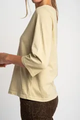 Remera color amarillo mostaza de algodón peinado, con escote redondo y mangas 3/4. Corte ajustado al cuerpo.