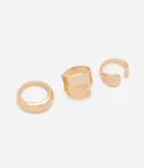 Kit de tres anillos de metal dorado con acabado brillante y formas orgánicas, incluyendo un diseño ovalado, uno ancho y asimétrico, y uno abierto.