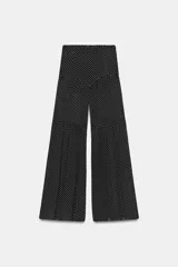 Pantalón de tiro medio con pierna ancha, confeccionado en viscosa con estampado de lunares. Presenta detalle de pliegues, forro corto interior y cierre con cremallera en la espalda.