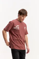 Remera oversize de algodón y poliéster color marrón, con cuello redondo, mangas cortas y estampa frontal con la inscripción "STREET VIBE DIVISION".