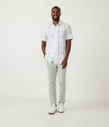 Pantalón de corte slim color gris claro, con cintura elástica, trabillas para cinturón, cierre de botón y cremallera, y bolsillos laterales y traseros.