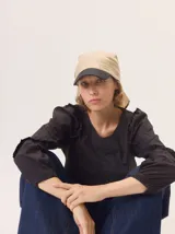 Gorro tipo pañuelo de lino color beige con visera negra.