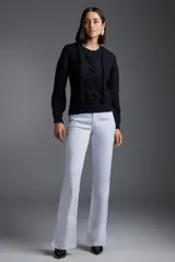 Sweater negro de punto con cuello redondo y mangas largas. Presenta tres flores tejidas en el frente y detalles de trenzas verticales.