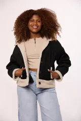 Campera tipo gamulán de color negro con interior y detalles en corderito color beige. Presenta cierre frontal con botones, cuello solapa y bolsillos laterales.