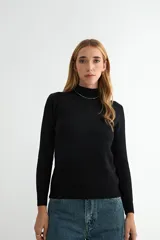 Buzo de punto color negro, con cuello alto y mangas largas, de diseño ajustado y tejido suave.