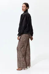 Pantalón de corte holgado en malla transparente, con estampado de leopardo, cintura elástica y piernas rectas.