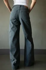 Jean de pierna ancha color gris oscuro, con cintura alta, bolsillos delanteros y traseros con detalle de trenzado, y cinturón de soga.