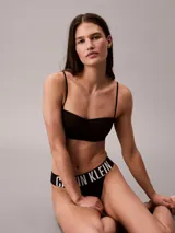Corpiño tipo bandeau de Calvin Klein confeccionado en microfibra elástica suave. Presenta copas ligeramente forradas, tirantes extraíbles y ajustables que permiten diversas formas de uso, y una banda elástica inferior con el logo de la marca.