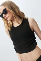 Top cropped color lila sin mangas y cuello a la base, con frunces en ambos laterales.